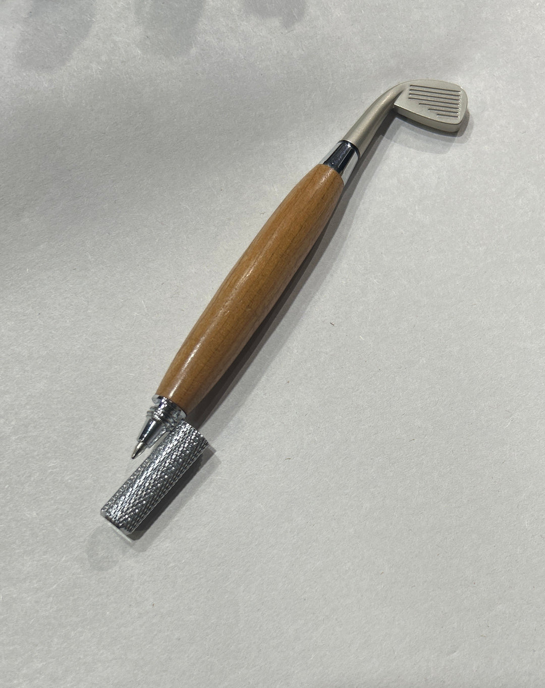 Ball point pen￼with a silver metal hardware and a nickel hardware golfing club. And cherry wood . friction finish.