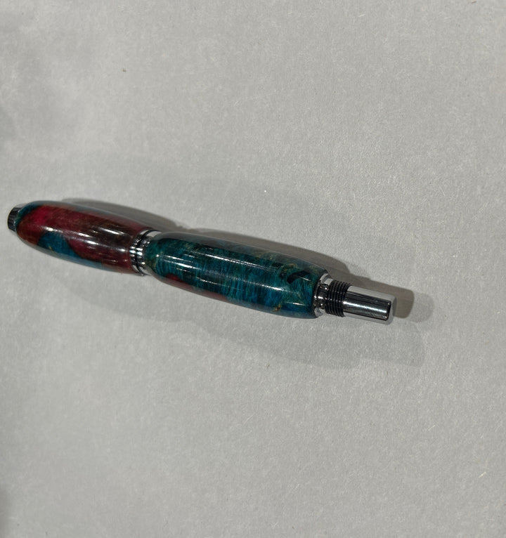 Roller ball pen with silver metal and black hardware with. And blue burl wood with pink little bit of brown acrylic a. CA finish.