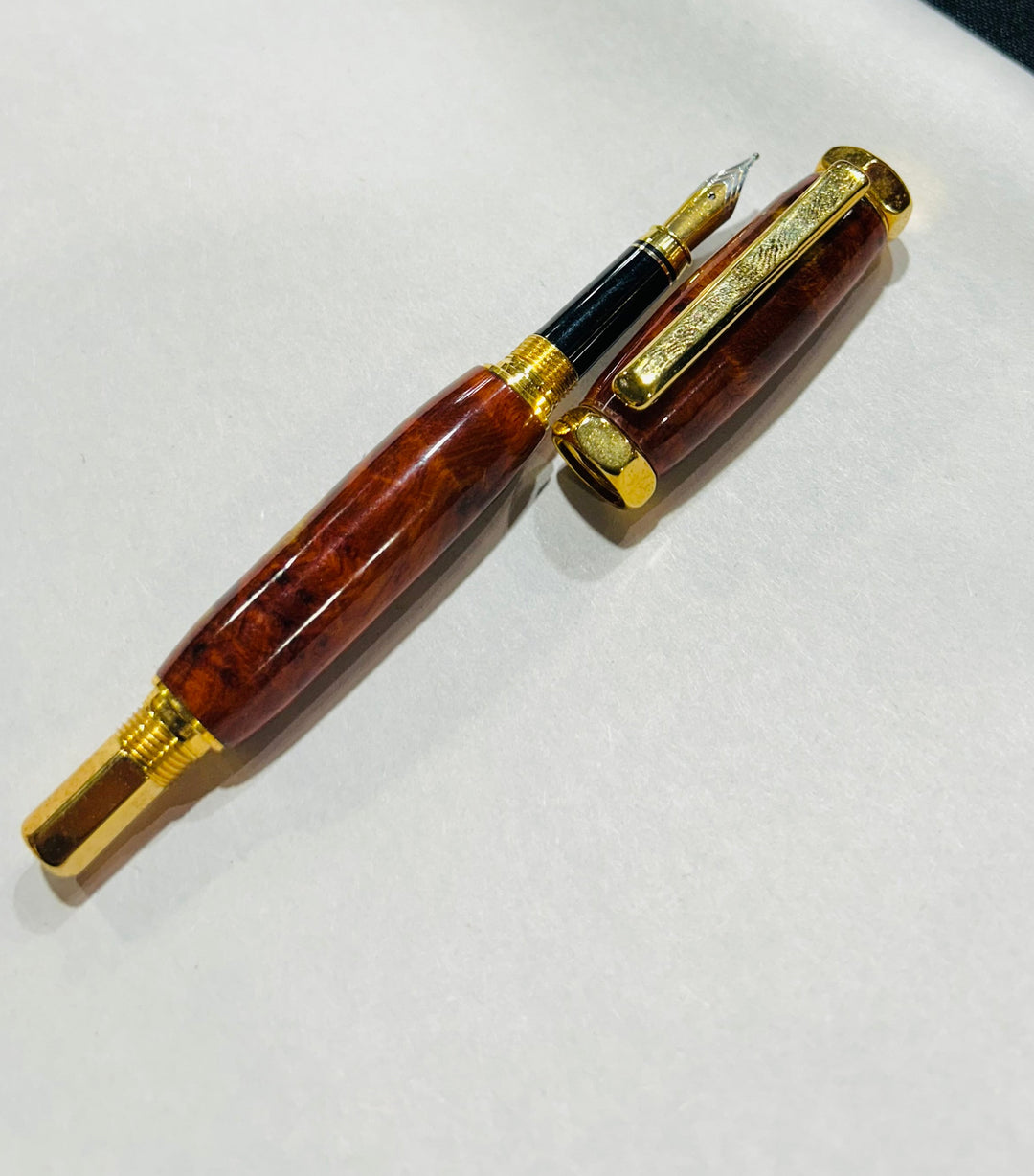 Fine point nib fountain pen with a gold metal hardware . And an Bueno burl wood.and a CA finish.