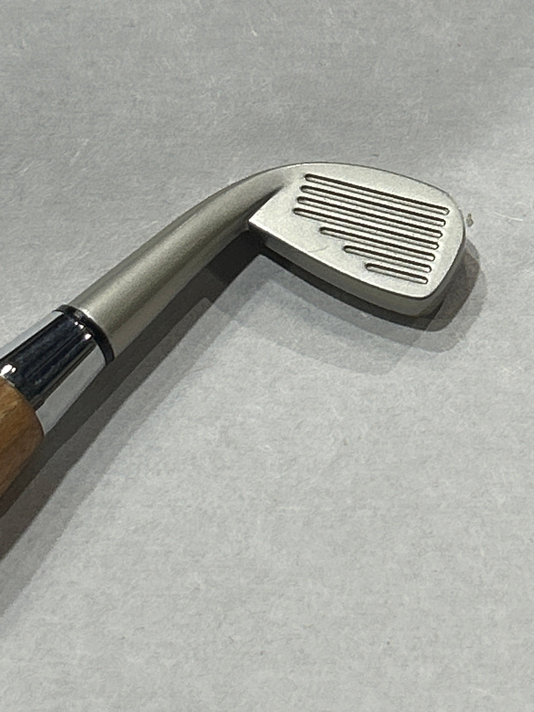Ball point pen￼with a silver metal hardware and a nickel hardware golfing club. And cherry wood . friction finish.