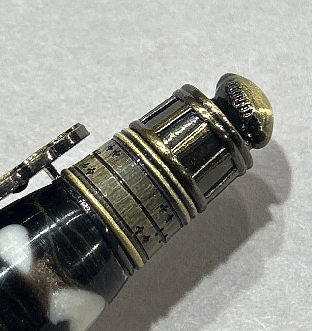 Ball point pen with a bronze metal love football live design, hardware . And a black and white acrylic . friction finish.