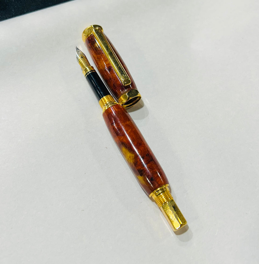 Fine point nib fountain pen with a gold metal hardware . And an Bueno burl wood.and a CA finish.