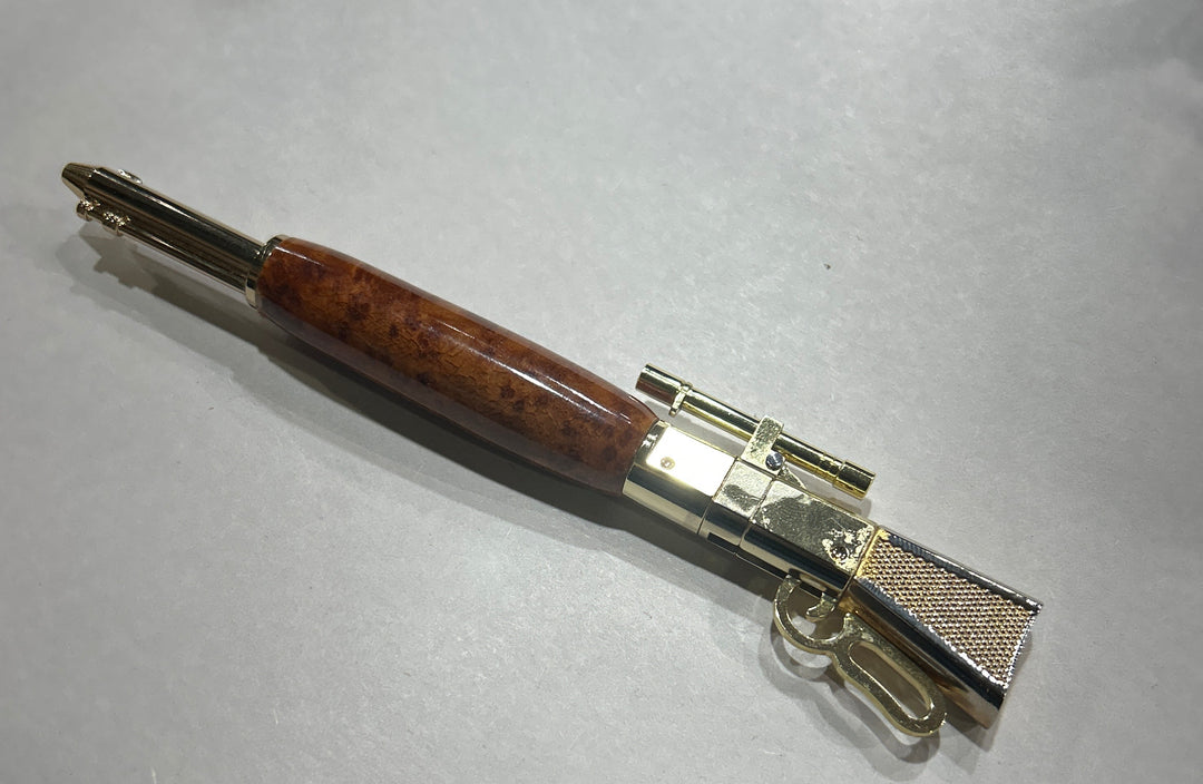 Ball point,  lever, action, rifle,pen with a gold pleaded metal design, hardware . And an Bueno wood . CA finish.