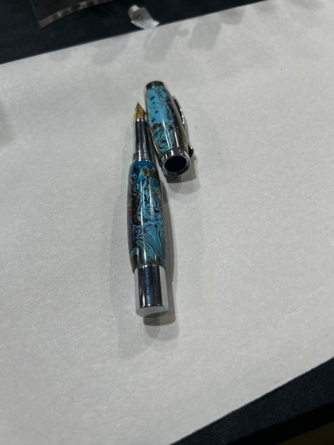 Fine point fountain pen with a silver metal  hardware . And light blue dark blue light brown acrylic . friction finish.