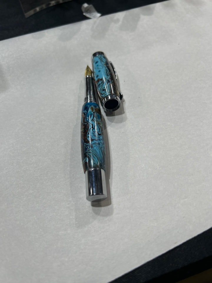 Fine point fountain pen with a silver metal  hardware . And light blue dark blue light brown acrylic . friction finish.