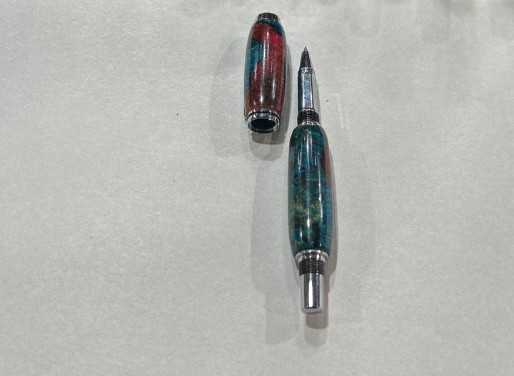 Roller ball pen with silver metal and black hardware with. And blue burl wood with pink little bit of brown acrylic a. CA finish.