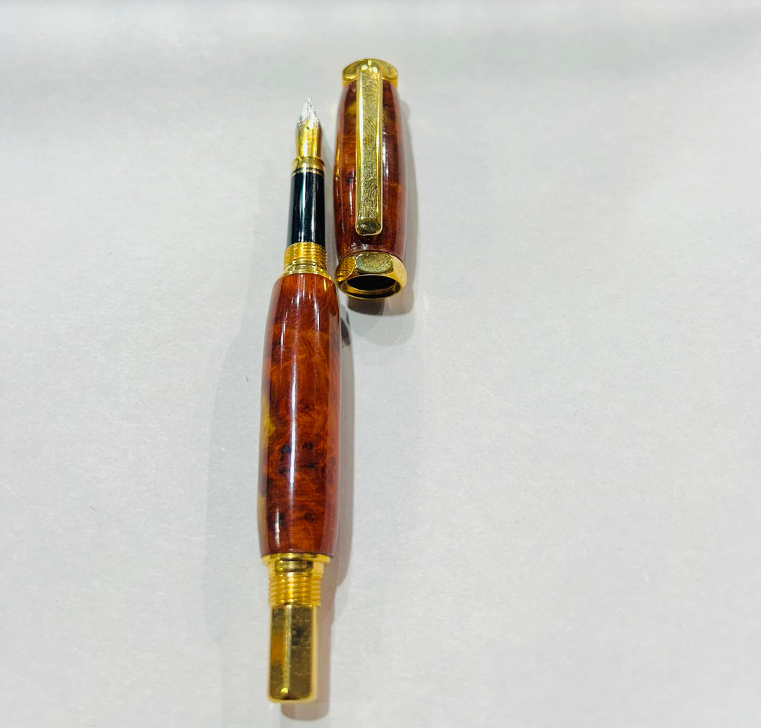 Fine point nib fountain pen with a gold metal hardware . And an Bueno burl wood.and a CA finish.