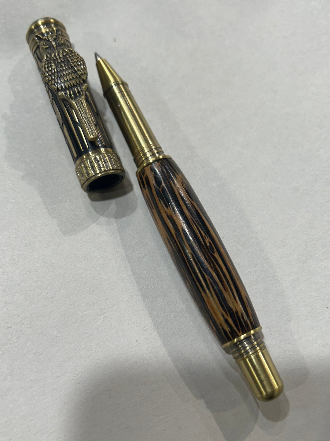 Roller ball pen with a bronze metal I will design owl. And a in black pine wood . friction finish.
