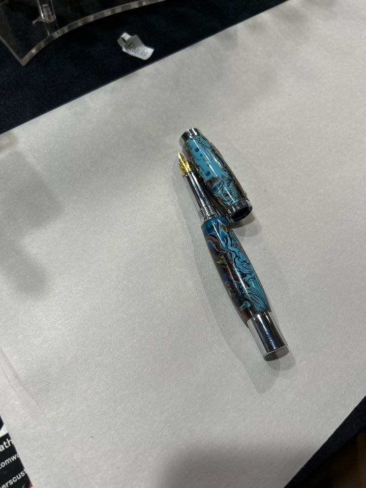 Fine point fountain pen with a silver metal  hardware . And light blue dark blue light brown acrylic . friction finish.