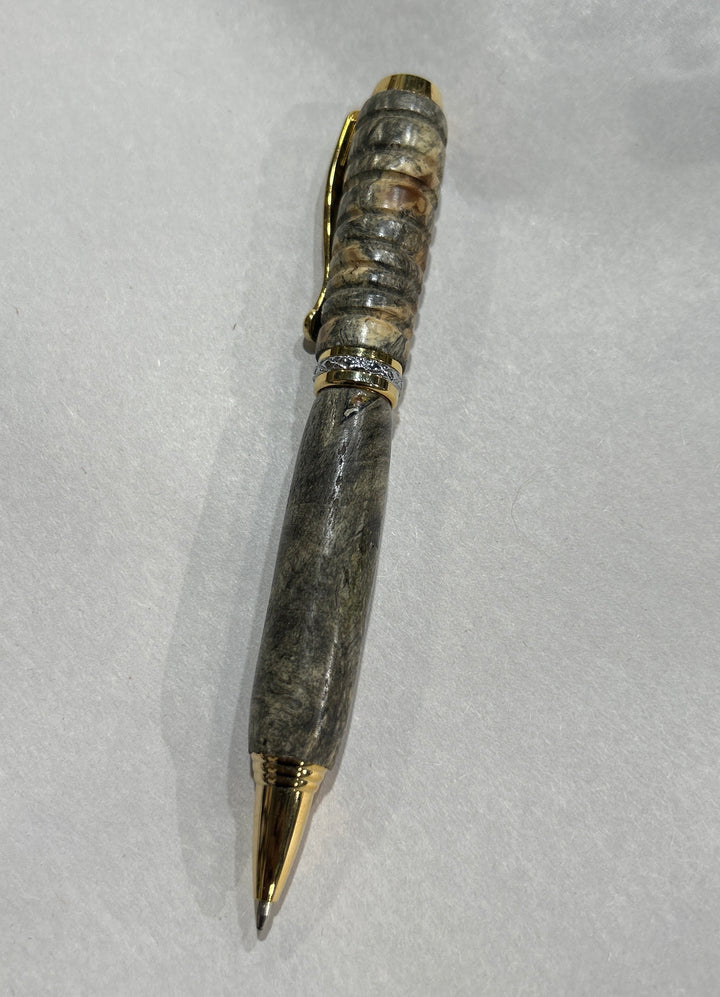 Ball point pen with silver and gold metal  hardware . And buckeye Burl wood . Friction polish.