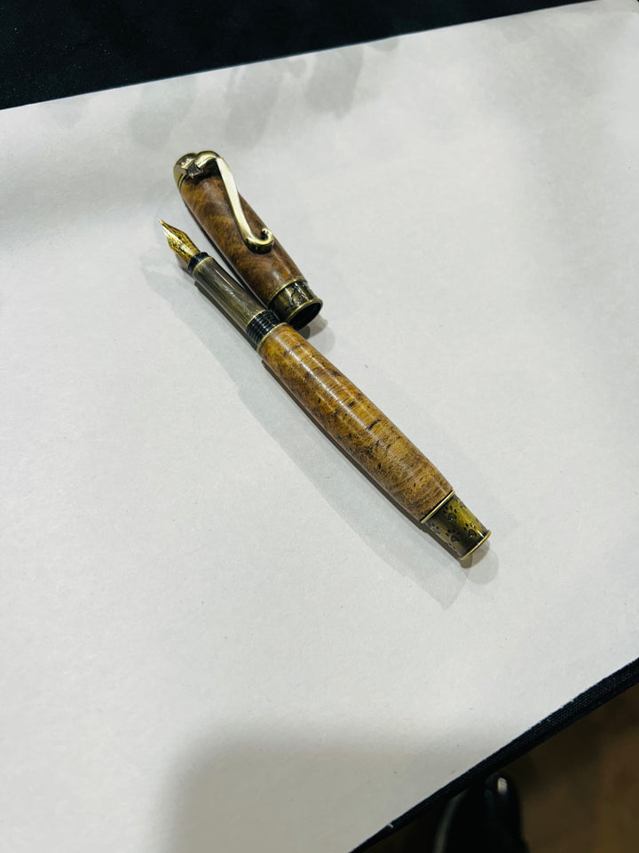 Copy) medium point nib fountain pen with a bronze metal cat design, hardware . And a in pecan wood . friction finish.