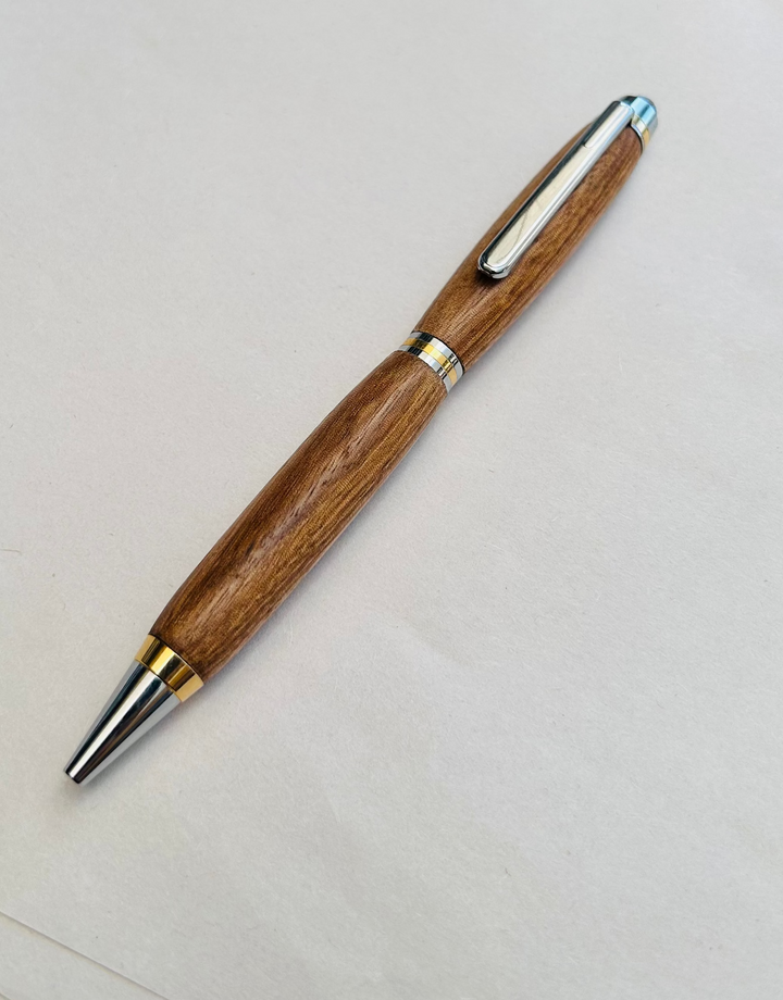 Ball point pen with silver and gold metal  hardware and stylus. And pecan wood . Friction polish.