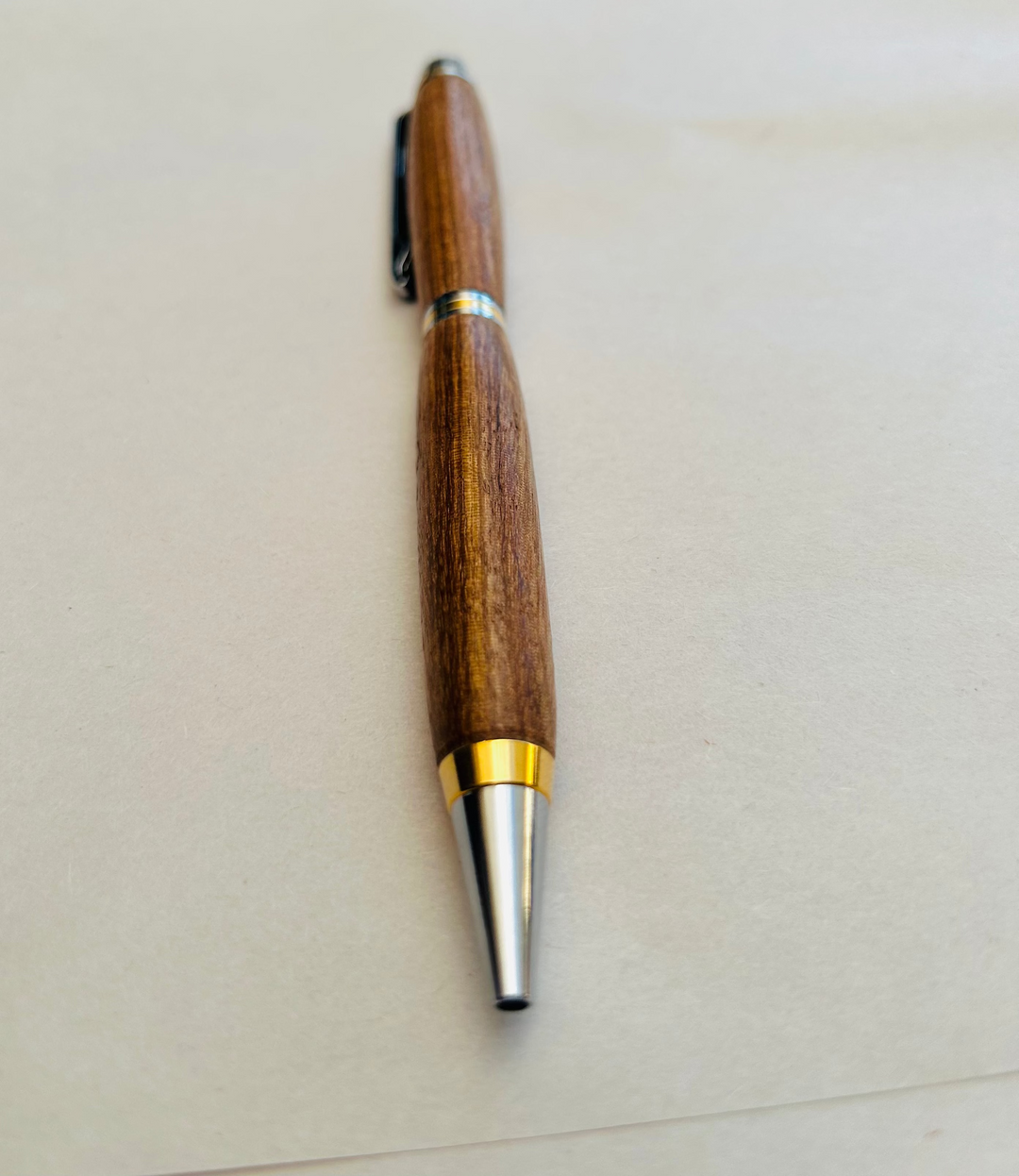 Ball point pen with silver and gold metal  hardware and stylus. And pecan wood . Friction polish.