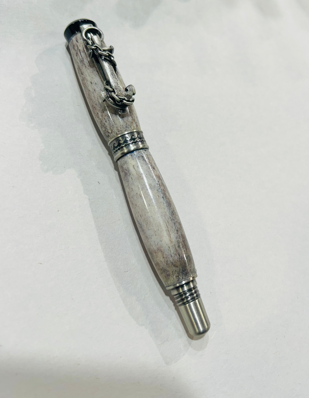 Roller ball pen with a brush nickel, metal and black hardware with ocean themed. And deer antler. CA finish.