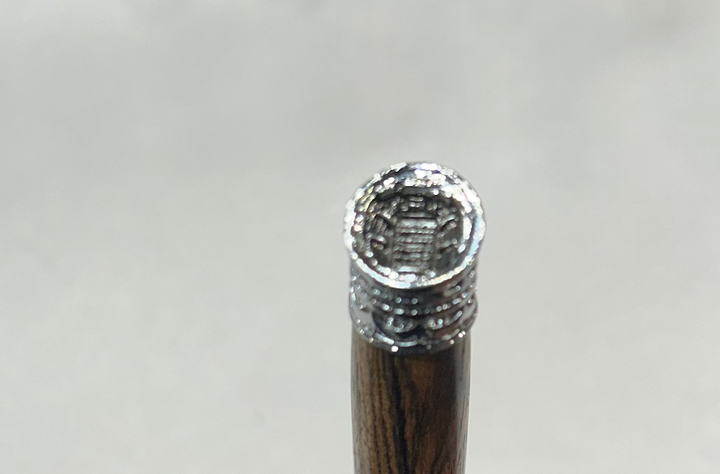 Ball point pen with a silver metal  hardware. And football thing. Bcody Wood .and friction finish.