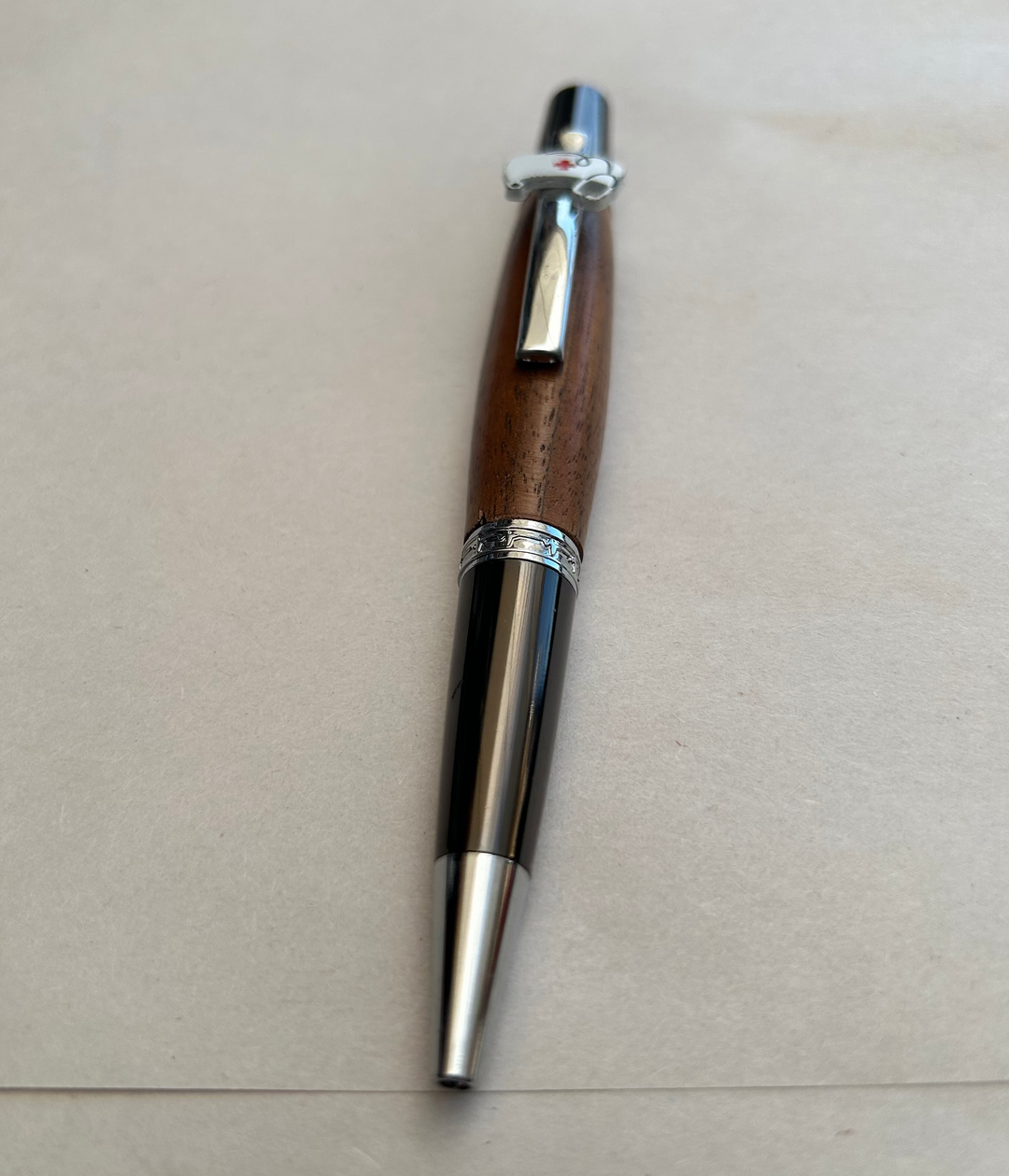 Ball point pen with silver and gun metal  hardware  with the nurse themed peace on it and stylus. And walnut wood. Friction polish.